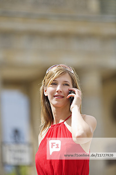 Hübsche blonde Frau beim Sightseeing in Berlin und beim Telefonieren