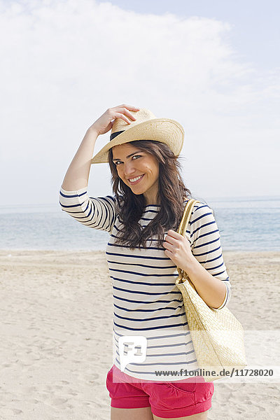 Portrait of a young brunette woman arriving at the beach