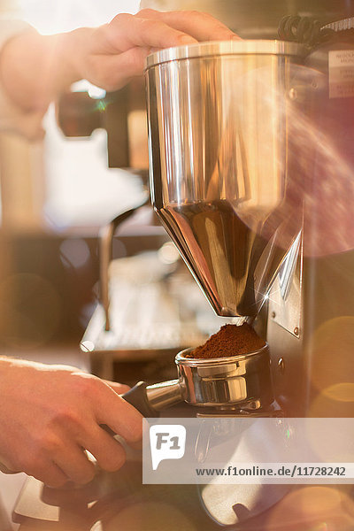 Close up barista using espresso machine grinder