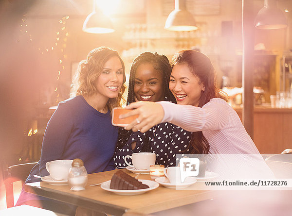 Lächelnde Frauen Freunde nehmen Selfie mit Kamera-Handy im Café Tisch