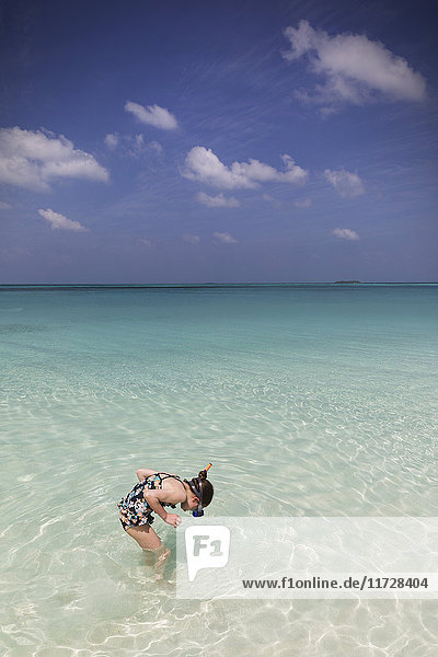 Girl snorkeling in tropical blue ocean