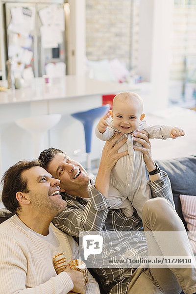 Portrait playful cute baby son with male gay parents