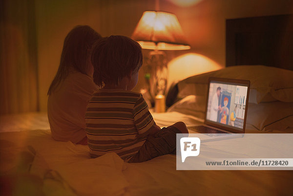 Junge und Mädchen Bruder und Schwester beobachten Video auf Laptop auf dem Bett