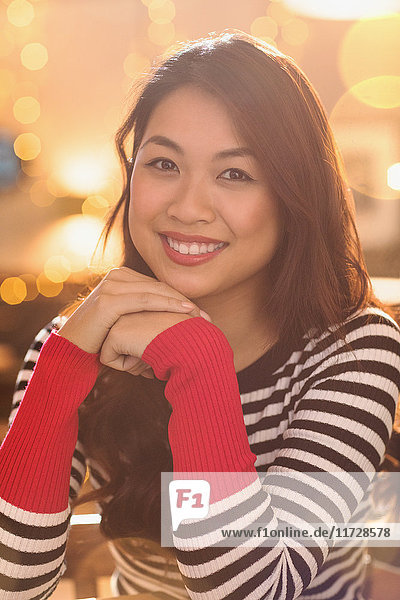 Porträt einer lächelnden Chinesin mit gestreiftem Pullover