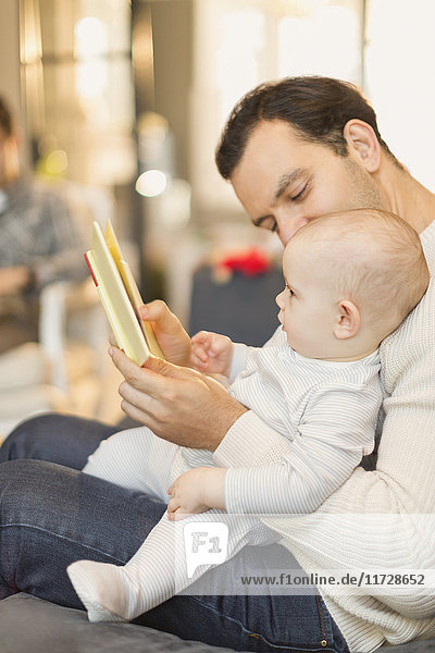 Father reading book to cute baby son