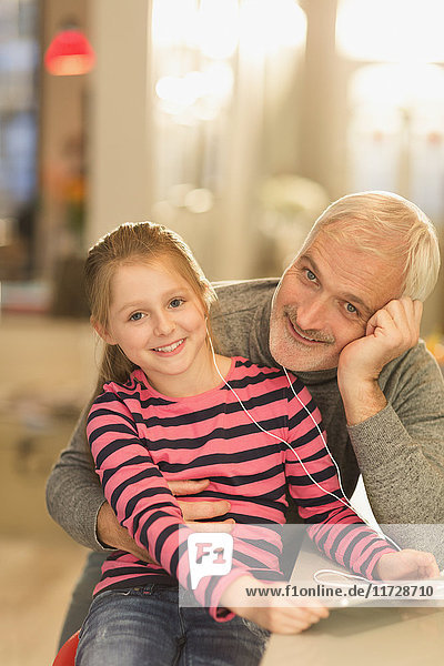 Portrait lächelnd Vater und Tochter verbinden  Kopfhörer teilen und digitales Tablett benutzen