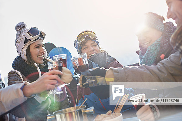 Skifahrerfreunde toasten Cocktailgläser Apres-Ski