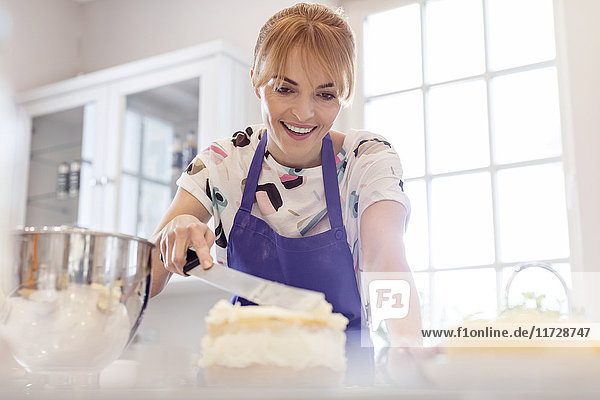 Lächelnde Frau beim Backen, Sahnetorte in der Küche