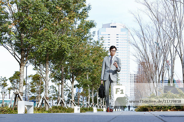 Japanese businessman with smartphone downtown Tokyo  Japan