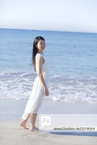 Young Japanese woman in a white dress by the sea  Chiba  Japan