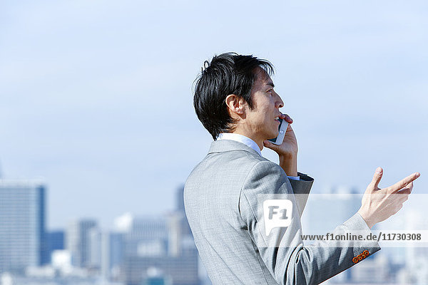 Japanischer Geschäftsmann am Telefon in der Innenstadt von Tokio  Japan