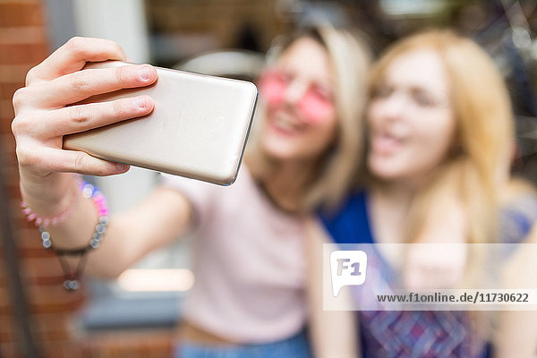 Zwei Freundinnen im Freien Selbsthilfe mit Smartphone