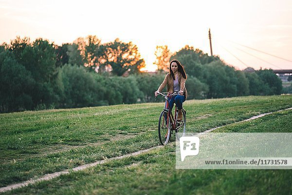 Frau fährt Fahrrad auf Gras