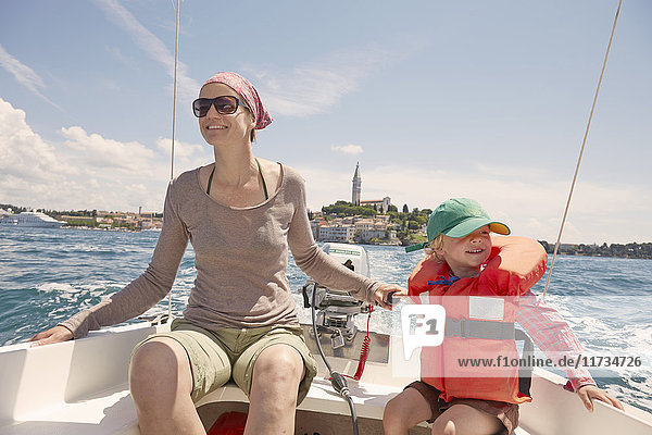 Ältere Frau mit Sohn steuert Motorboot  Rovinj  Halbinsel Istrien  Kroatien