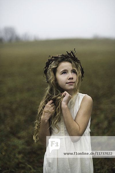 Porträt eines langhaarigen blonden Mädchens  das vom Feld aufblickt