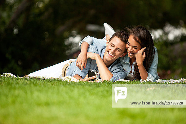 Junges Paar im Park liegend  lächelnd