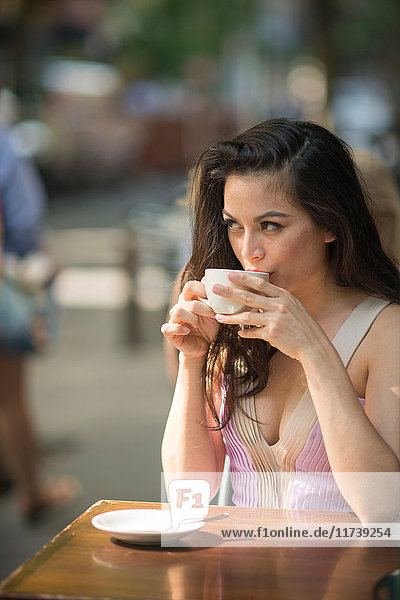 Mittelgroße erwachsene Frauen trinken Kaffee in Straßencafé