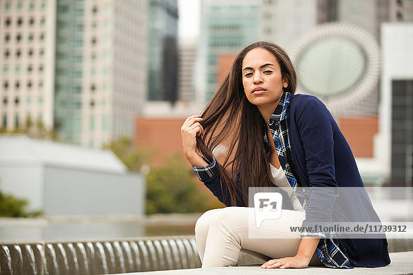 Junge Frau in der Stadt sitzend  Porträt