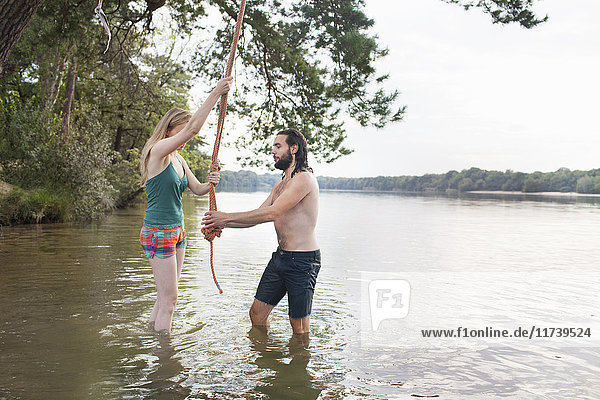 Junges Paar schwingt Seil über dem See