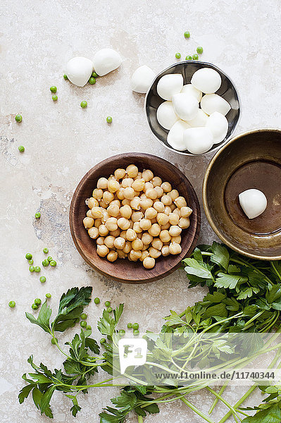 Nahrungsmittelstillleben mit Schalen mit Kichererbsen  Mozzarella und Petersilie