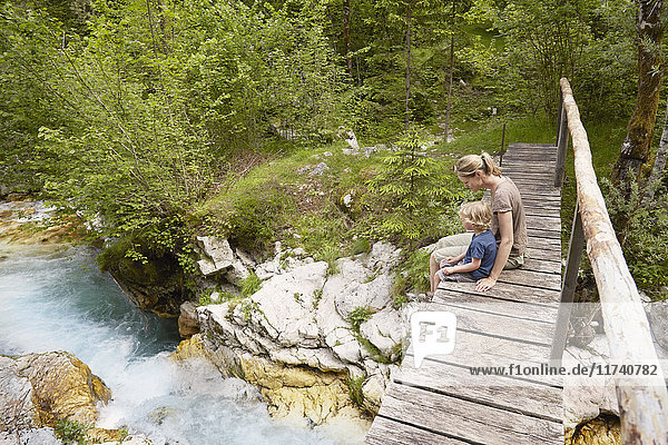 Reife Frau mit Sohn auf Holzsteg sitzend  Bovec  Soca  Slowenien