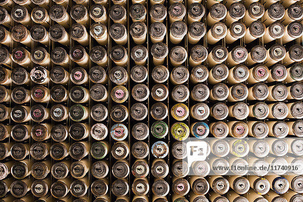 Reihen von Spitzenklöppeln auf alter Webmaschine in Textilfabrik