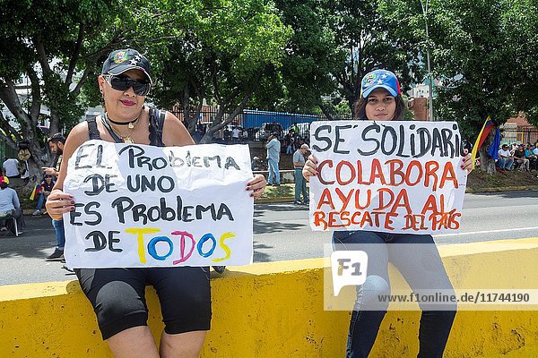 A lady and her daughter protest with posters in search of solidarity. Venezuelan citizens  opposed to the government of Nicolas Maduro  stayed for 12 hours in the 'Gran Plantón' of the distributor Altamira  on the highway Francisco Fajardo. May  15  2017.