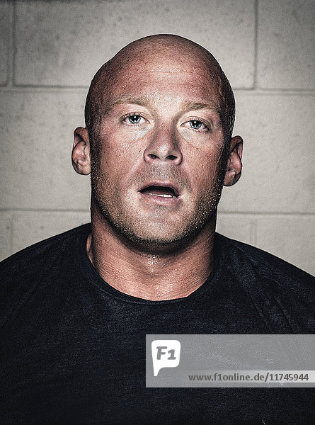 Portrait of bald young man with open mouth after workout