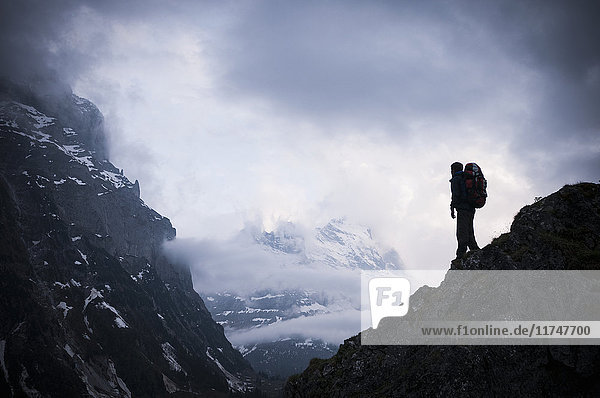 Man standing on rocks with Mount Eiger in background  Bernese Oberland  Switzerland