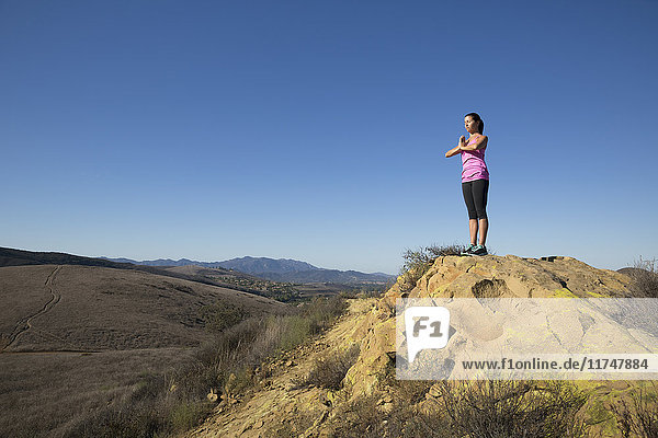 Woman practicing yoga on top of hill  Thousand Oaks  California  USA
