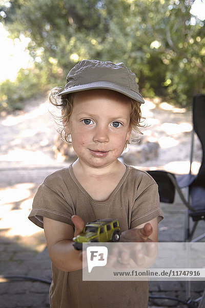 Porträt eines Jungen  der ein Spielzeugauto hält