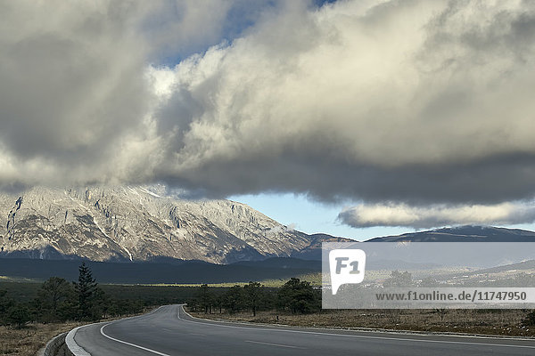 Abnehmende Perspektive der leeren Straße zum Schneeberg des Jadedrachens Lijiang Yunnan China