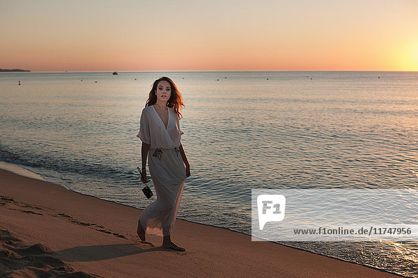 Junge Frau spaziert bei Sonnenuntergang am Strand  Castiadas  Sardinien  Italien