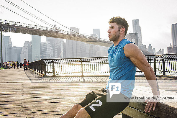 Young man doing reverse push ups on riverside  Brooklyn  New York  USA
