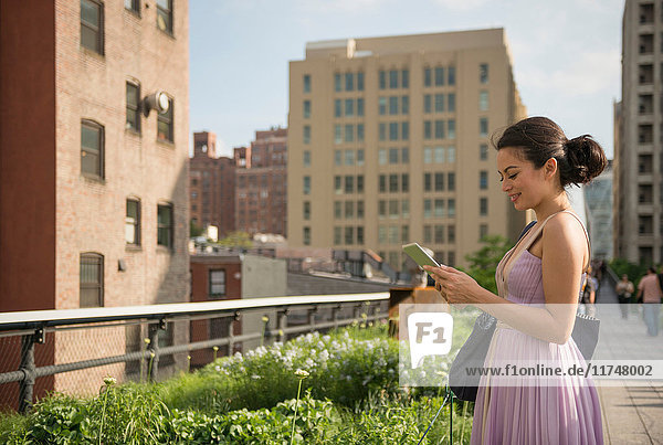 Mittelgroße erwachsene Frauen mit digitalem Tablet im High Line Park  New York City