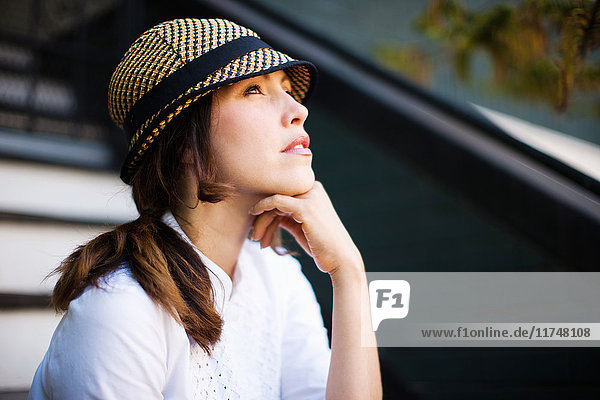 Mid adult woman wearing hat and looking up