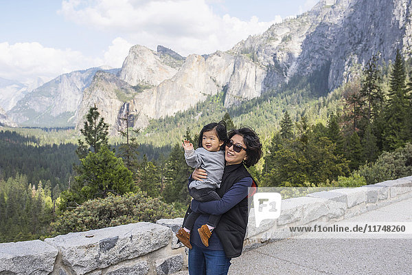 Mature woman carrying granddaughter  Yosemite National Park  California  USA