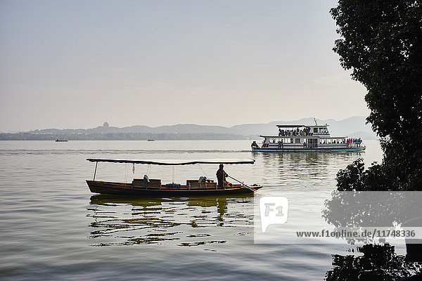 View of silhouetted fishing boat and river boat on Westlake  Hangzhou  China