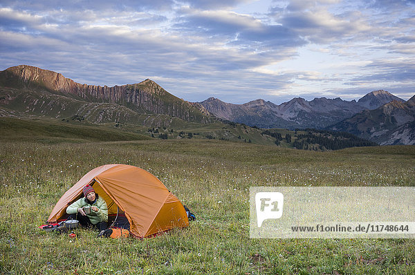 Woman camping  Hasley Basin  West Elk Mountains  Colorado  USA