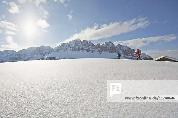 Fernsicht auf Schneeschuhwanderung eines mittleren Erwachsenenpaares  Dolomiten  Eisacktal  Südtirol  Italien