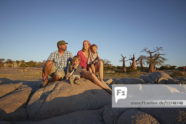 Familie sitzt auf einem Felsen und schaut auf die Aussicht  Gweta  makgadikgadi  Botswana