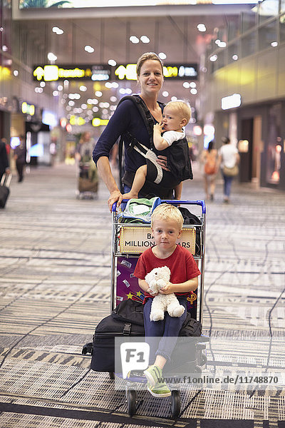 Portrait of mid adult woman and two children at Singapore Airport