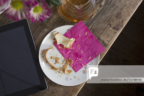 Plate with crumbs and digital tablet