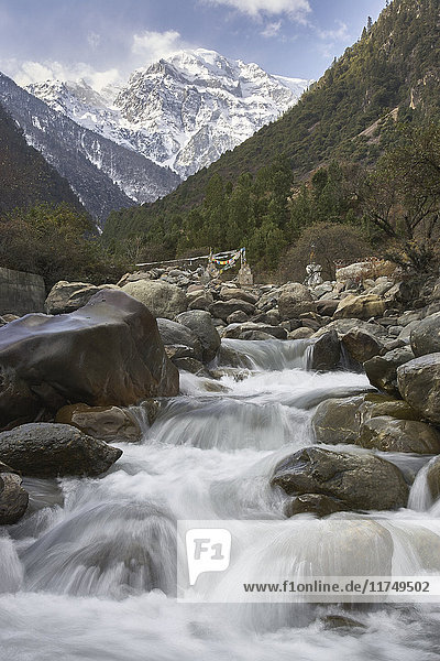 Vom schneebedeckten Berg flussabwärts fließendes Wasser Bezirk Shangri-la Yunnan China