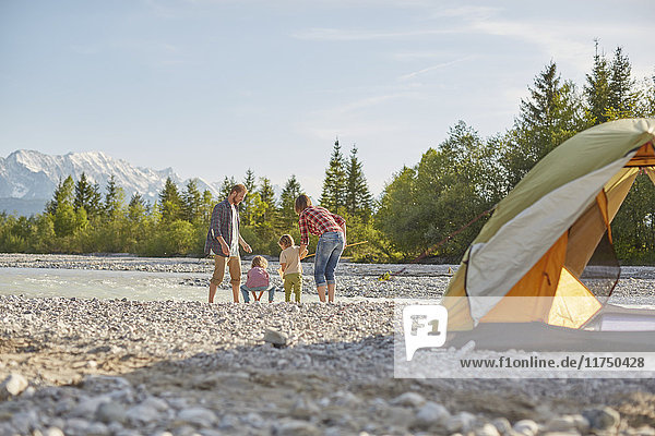 Rückansicht einer Familie  die mit dem Zelt im Fluss spielt  Wallgau  Bayern  Deutschland