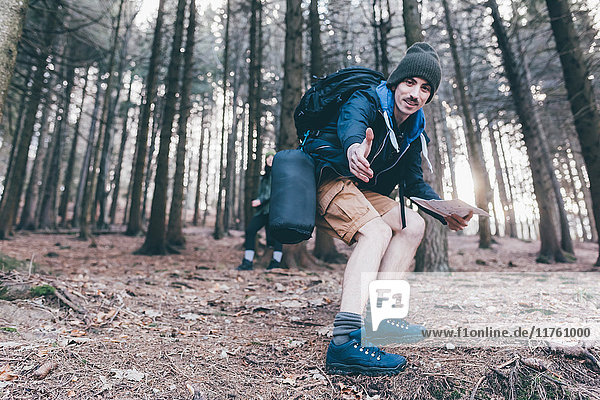 Mann wandert in steilem Wald und bietet eine helfende Hand  Monte San Primo  Italien