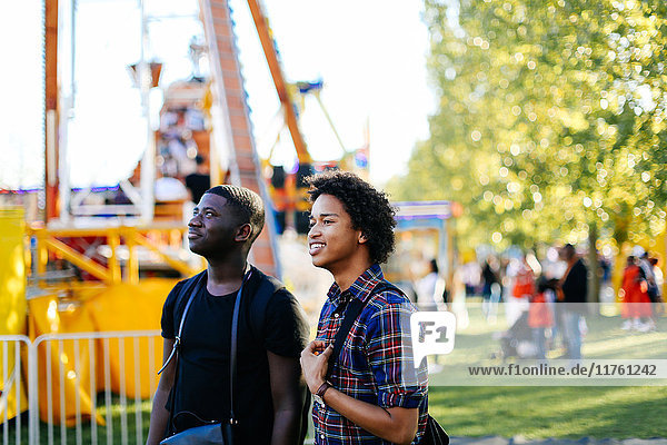 Two male friends at funfair  smiling