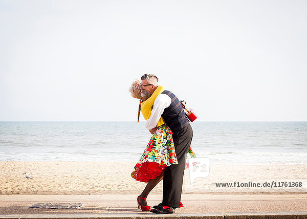 1950er-Jahre-Paar im Vintage-Stil  das sich am Strand umarmt
