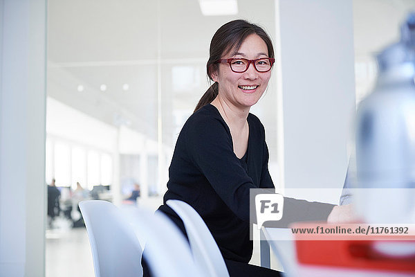 Portrait of businesswoman in office looking at camera smiling