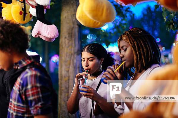 Freunde auf Kirmes  Mädchen trinken Eisgetränke